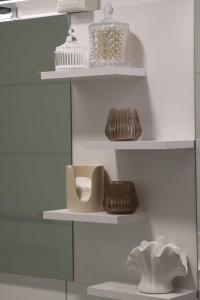 a shelf with plates and vases on it at City-Apartment Braunschweig in Braunschweig