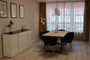 a dining room with a wooden table and black chairs at City-Apartment Braunschweig in Braunschweig +19 photos
