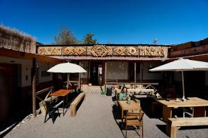 an outdoor patio with tables and chairs and umbrellas at Vientos - La Yareta in San Pedro de Atacama
