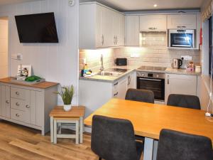 a kitchen with a wooden table and a dining room at Lodge 6- Uk51084 in Lyme Regis