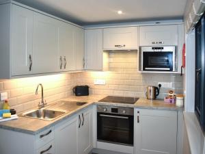 a kitchen with white cabinets and a sink at Lodge 6- Uk51084 in Lyme Regis