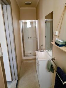 a bathroom with a white sink and a shower at Lakes Entrance Holiday Units in Lakes Entrance +34 photos