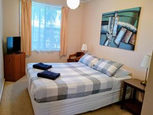 a bedroom with a bed with two towels on it at Lakes Entrance Holiday Units in Lakes Entrance