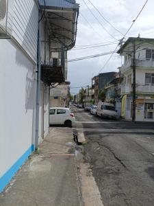 a street with a white car parked next to a building at TRANSIT AFFAIRES - LOISIRS in Pointe-à-Pitre