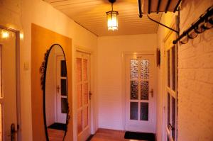 a hallway with a mirror and a door with a light at Vledderstee in Vledderveen