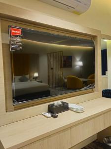 a reflection of a hotel room with a bed in a mirror at Al Seef Hotel in Al-ʿUla