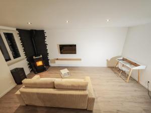 a living room with a couch and a piano at L'immeuble du Monde Rose - Appartements neufs climatisés - classés 3 étoiles - Vic le Comte - Auvergne in Vic-le-Comte