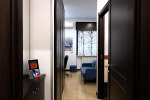 a room with a hallway with a blue chair and a door at B&B Studio83 Pompei in Pompei