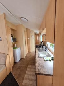 a small kitchen with a sink and a counter at Caravan Galiccy in Kinmel Bay
