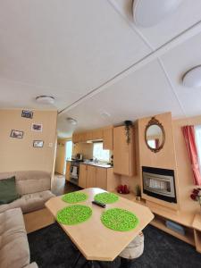 a living room with a table and a couch at Caravan Galiccy in Kinmel Bay