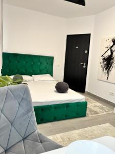 a bedroom with a bed with a green headboard at EriSSSo House Murfatlar in Murfatlar