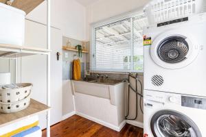 a laundry room with a washing machine and a sink at Kaimana in Gold Coast