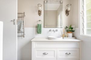 a white bathroom with two sinks and a mirror at Kaimana in Gold Coast +55 photos