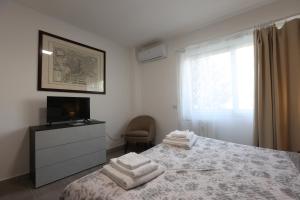 a bedroom with a bed and a television and towels at Sweet Home Fleming in Rome