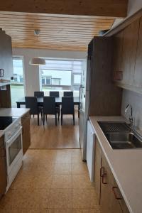 a kitchen and dining room with a table and chairs at Sigtun 55 in Patreksfjörður