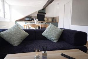 a blue couch with pillows in a living room at Le Perchoir Charm and light in Pau