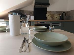 a table with bowls and spoons on a kitchen counter at Le Perchoir Charm and light in Pau +5 photos
