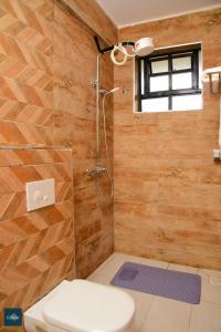 a bathroom with a shower with a toilet and a window at Fahari Cedar House in Kericho +43 photos