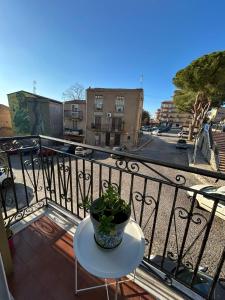 a table with a potted plant on a balcony at La Casa del Sole in Corleone