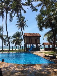 a swimming pool with a tree house and a playground at Oceanfront Executive Serviced Apartment Mbezi Beach in Dar es Salaam