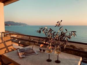 a table with two wine glasses and a plant on it at Glyfada Seaview Home 126 by New Era in Glyfada