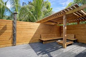 a wooden patio with a bench and a pergola at POOL AC King Bed Cozy Rooms - Villa Vaiaire in Vaïare