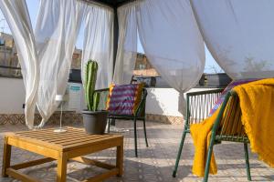 ein Balkon mit Stühlen, einem Tisch und einem Kaktus in der Unterkunft Curò in Cinisi