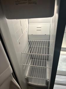 an empty refrigerator with its door open with its shelves at The Relaxing Home in Memphis