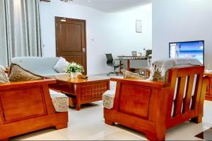 a living room with wooden furniture and a couch at Oceanfront Executive Serviced Apartment Mbezi Beach in Dar es Salaam