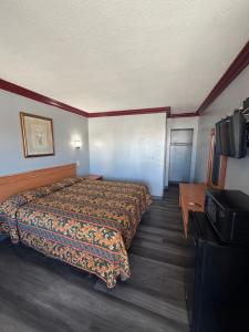 a hotel room with a bed and a flat screen tv at Harbor Inn in Harbor City +8 photos