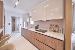 a kitchen with a sink and a counter with chairs at SOLUNA Hideaway Athens - Luxury Jacuzzi Suite in Athens +19 photos