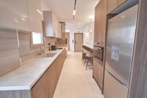 a large kitchen with wooden cabinets and a sink at SOLUNA Hideaway Athens - Luxury Jacuzzi Suite in Athens