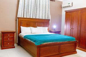 a bedroom with a bed with a wooden headboard at Oceanfront Executive Serviced Apartment Mbezi Beach in Dar es Salaam +24 photos
