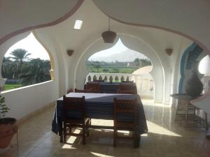a dining room with a table and chairs in a building at Cleopatra Hotel Luxor in Luxor