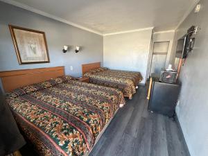 a hotel room with two beds and a tv at Harbor Inn in Harbor City