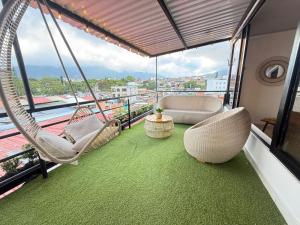 a balcony with chairs and a hammock on a building at toba Hotel- 5 min Centro Ibague in Ibagué