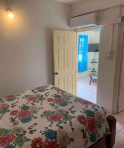 a bedroom with a bed with a floral bedspread at Duncan Apartment #1 in Port Elizabeth