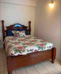 a bedroom with a bed with a floral bedspread at Duncan Apartment #1 in Port Elizabeth