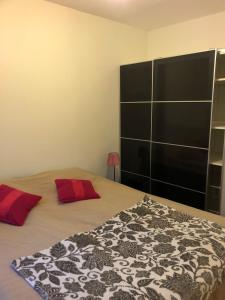 a bedroom with a bed with red pillows on it at Guest house Norrköping in Norrköping