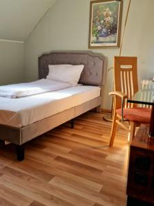 a bed in a room with a wooden floor at Apartments by Pension Pale Bach in Bad Hersfeld