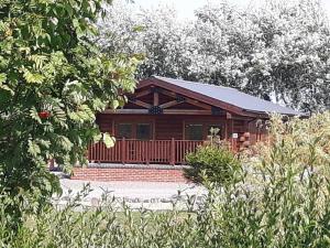 a log cabin with a porch and stairs in front at No 6 Lake View Lodges - 28283 in Old Leake
