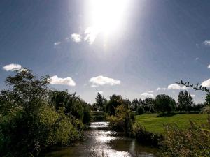 a river with the sun in the sky at No 6 Lake View Lodges - 28283 in Old Leake