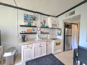 a kitchen with white cabinets and white appliances at Pirates Bay B114 in Fort Walton Beach