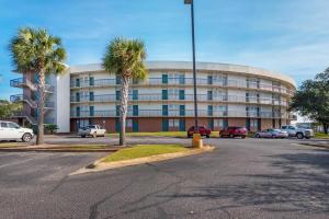 a building with palm trees in front of a parking lot at Pirates Bay B114 in Fort Walton Beach