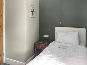a bedroom with a bed and a side table with a lamp at Hazeldene in Bishopston +3 photos