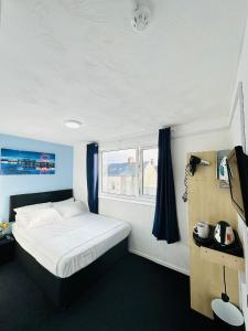ein Schlafzimmer mit einem weißen Bett und einem Fenster in der Unterkunft Hotel Vibes in Blackpool