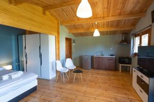 a kitchen with a refrigerator and two white chairs at Golden Sun Bungalows in Palaiokatoúna
