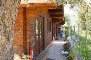 a log cabin with a porch and a tree at Golden Sun Bungalows in Palaiokatoúna
