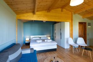 a bedroom with a bed and a couch and chairs at Golden Sun Bungalows in Palaiokatoúna +12 photos