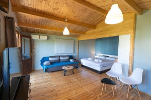 a living room with a bed and a couch at Golden Sun Bungalows in Palaiokatoúna